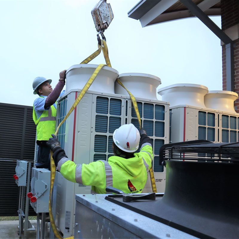 Two men from Harvey W Hottel. Inc. installed a commercial AC unit in the DC Metropolitan Area.